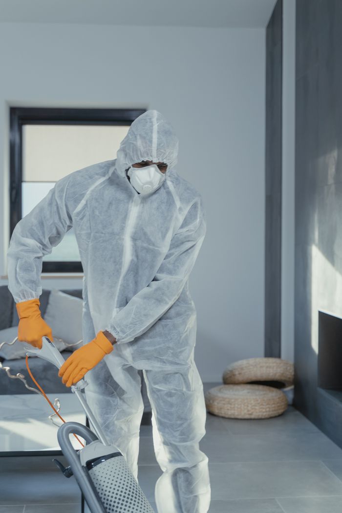 home-img Une personne équipée de protections individuelles passe l’aspirateur à l’intérieur, pour garantir un nettoyage minutieux.